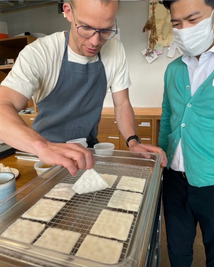Thomas Frebel preparing a dish using koji mycelium and the author Naoyuki Yanagihara